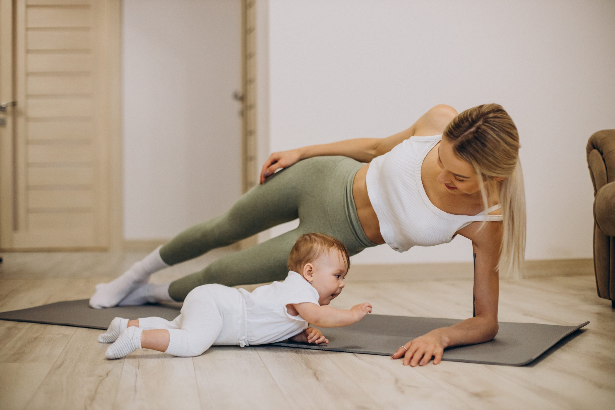 Mother practicing yoga with her baby daughter at home ReBirth: Възстановяване след бременност - Image 1